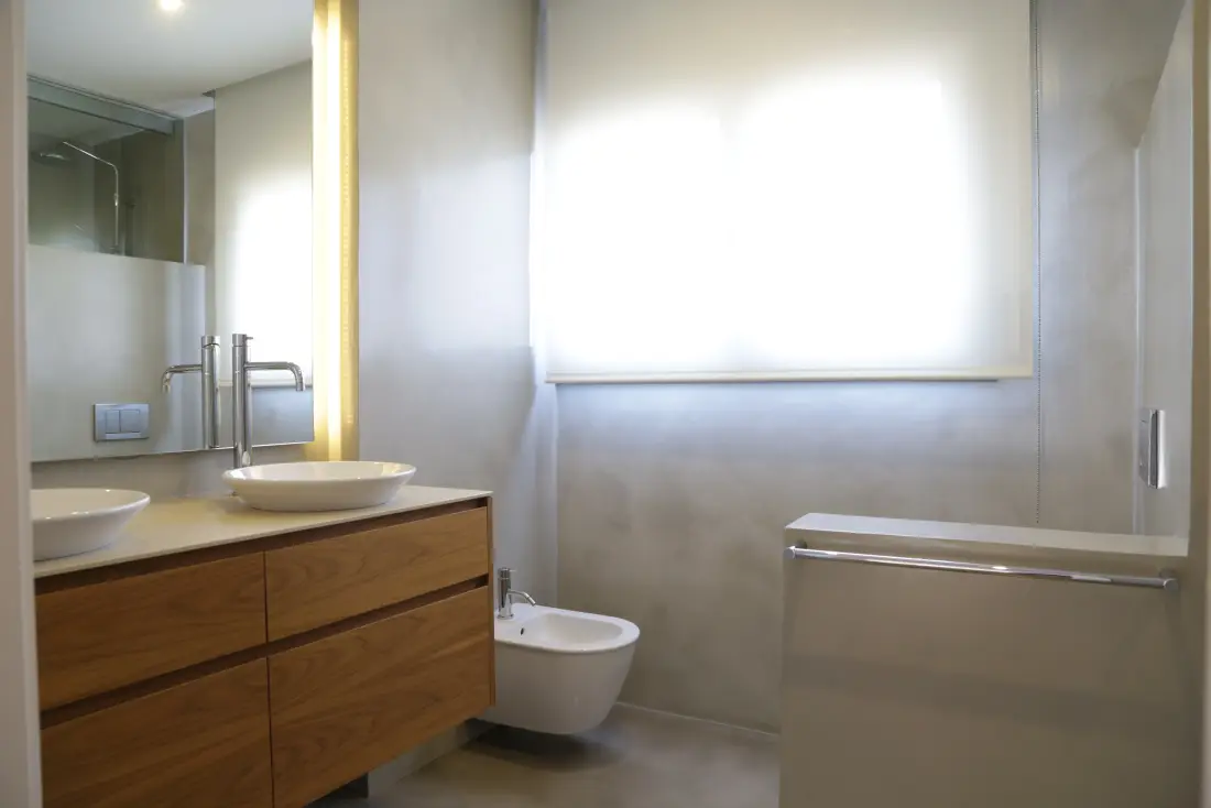 Reforma de baño con carpintería a medida en Barcelona, mueble de madera y espejo retroiluminado