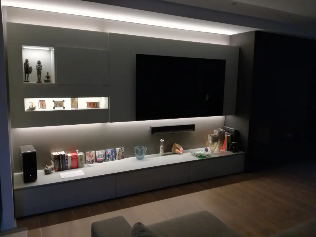 Salón con mueble de TV a medida e iluminación integrada, reforma integral en Barcelona