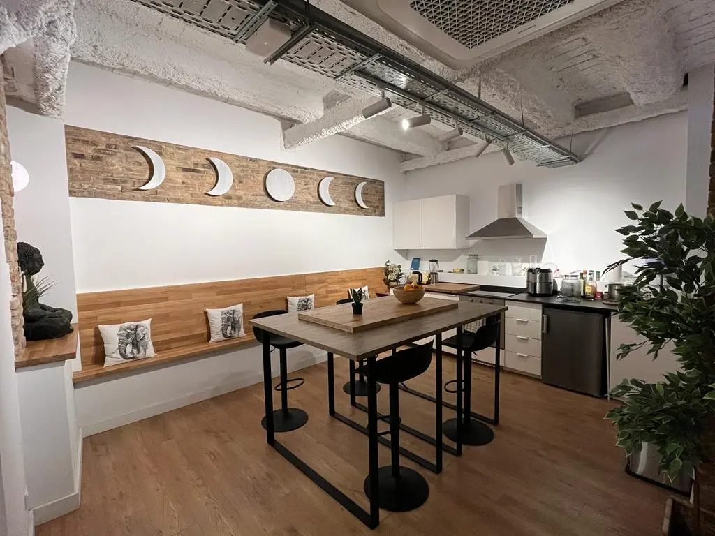 Comedor con banco tapizado a medida y cocina abierta, reforma integral Alpol en Barcelona